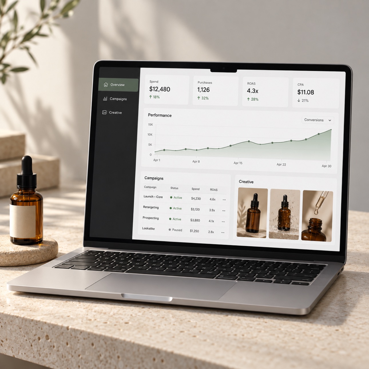 Laptop showing a skincare campaign workspace on a limestone desk.