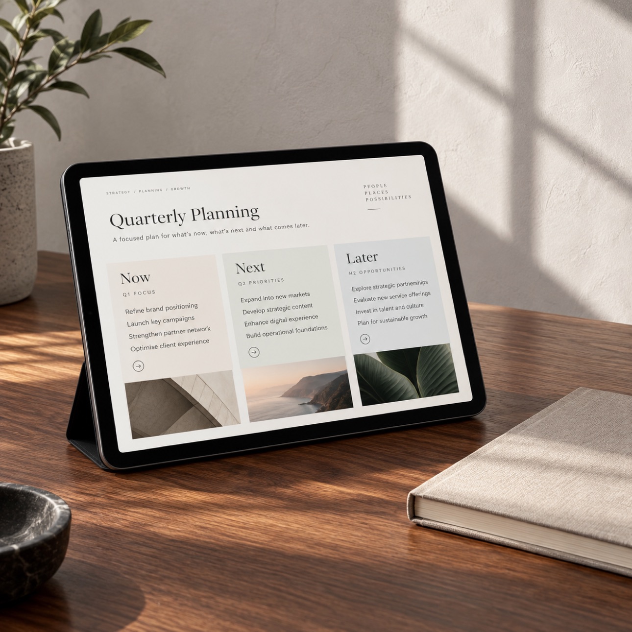 Tablet displaying a quarterly plan beside a simple notebook.